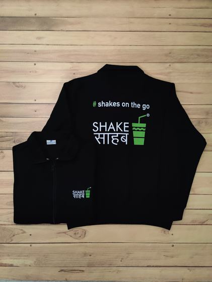 Black zip jackets with green and white printed shake cup logo and hashtag slogan on the back, custom made by RestroCart, New Delhi