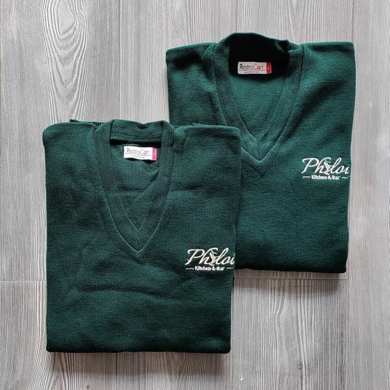 Two bottle green V-neck knit sweaters with white embroidered script logo on chest, folded, custom made by RestroCart, New Delhi