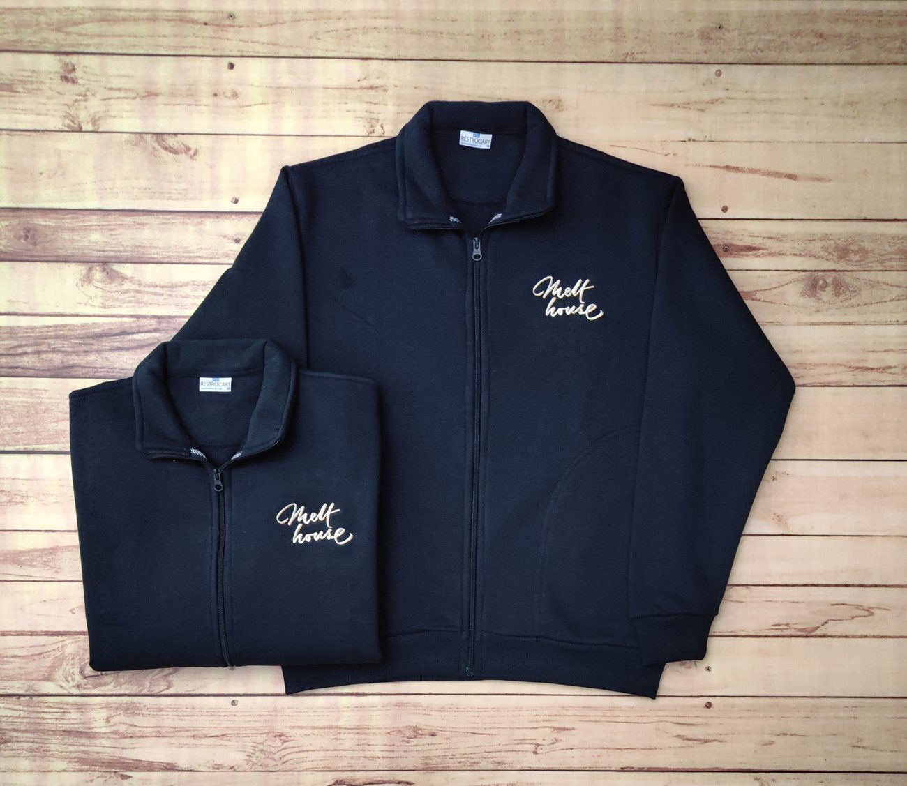 Navy fleece zipper jackets with a stand collar, side pockets and a white script logo embroidered on the chest, custom staff outerwear by RestroCart