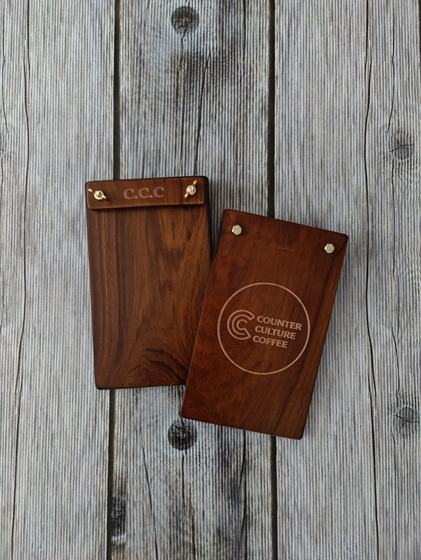 Pair of dark walnut menu clipboards with engraved header and round laser engraved coffee logo, custom made by RestroCart, New Delhi