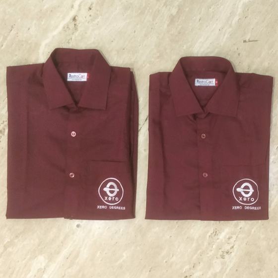 Two maroon full sleeve shirts with white embroidered round logo on lower front, folded, custom made for Xero Degrees by RestroCart, New Delhi