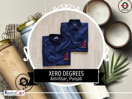 Two navy collared uniform shirts with red and white embroidered logo, folded, custom made for Xero Degrees by RestroCart, New Delhi